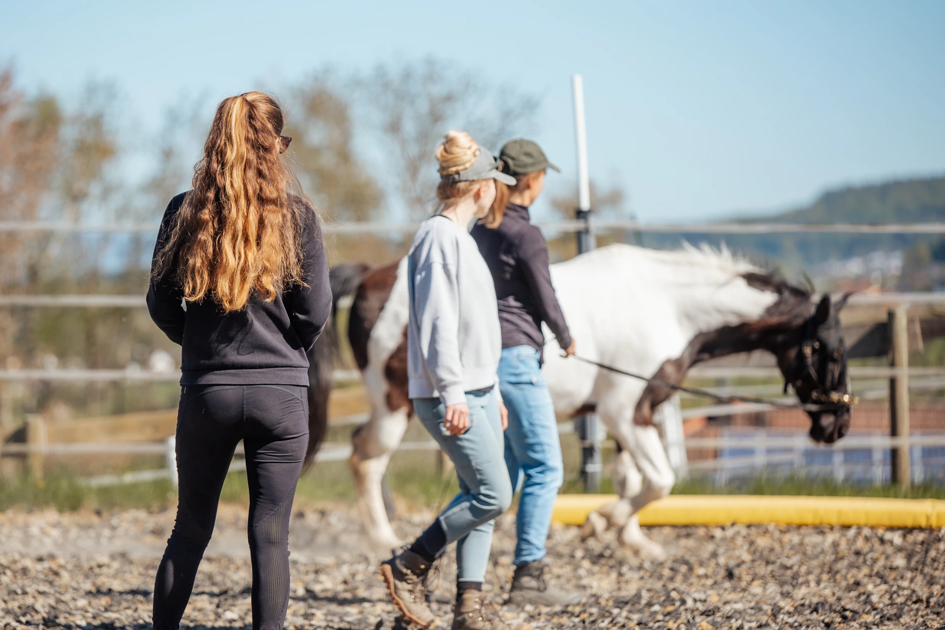 Jenny Richter mit Teilnehmerinnen und Pferden auf dem Reitplatz