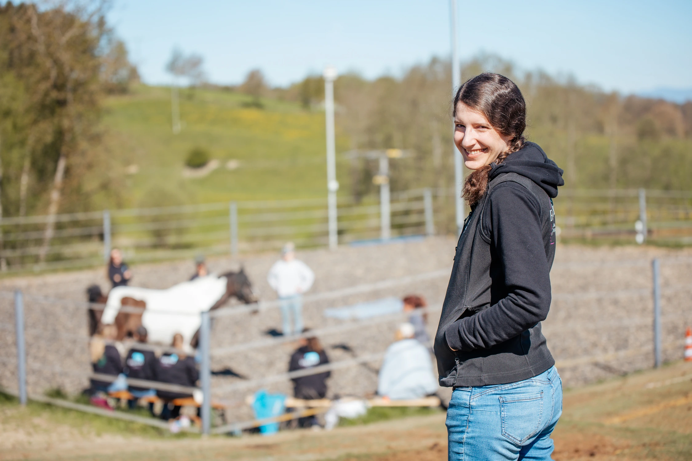 Christine lächelnd am Trainingsplatz der EquiZeit Akademie