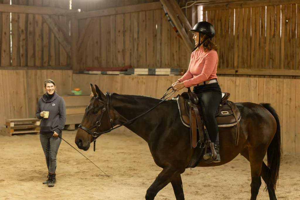 Pferdetrainerin erteilt einer Reitschülerin Unterricht auf ihrem Pferd für einen besseren Sitz